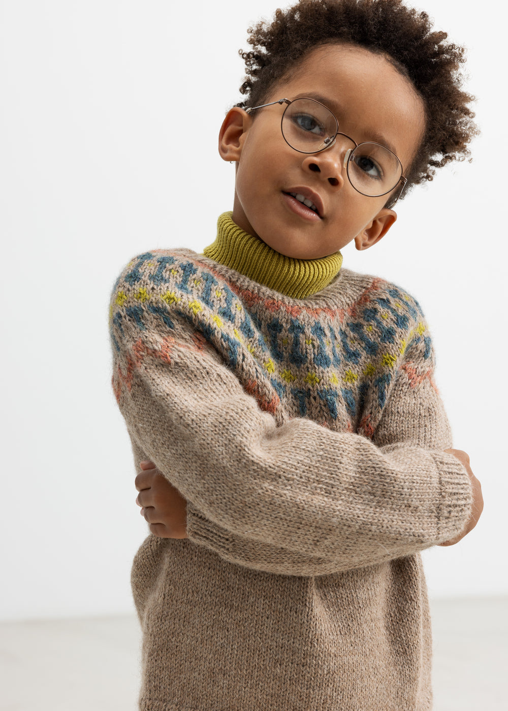 Børn i beige uldstrikbluse med farvet bærestykke