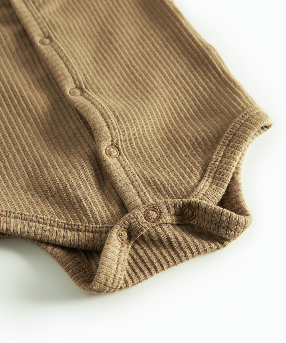 Brun ribstrikket babybody med knapper foran