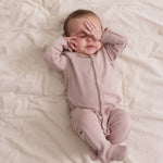 Baby i ribbstrikket lyserød heldragt til baby i blødt materiale med lange ærmer, lange ben, tryknapper og futter