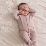 Baby i ribbstrikket lyserød heldragt til baby i blødt materiale med lange ærmer, lange ben, tryknapper og futter