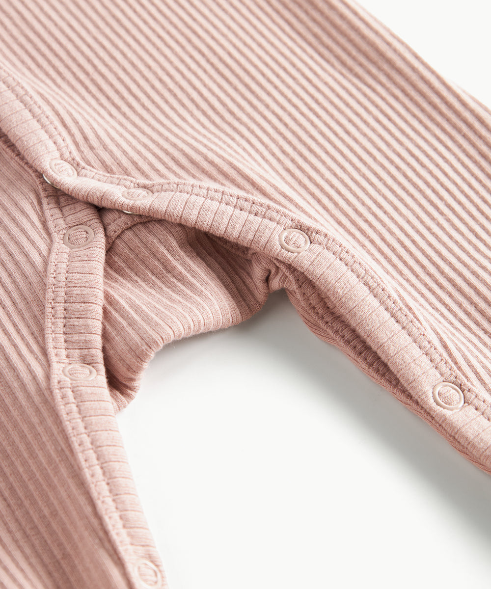 ribbstrikket lyserød heldragt til baby i blødt materiale med lange ærmer, lange ben, tryknapper og futter