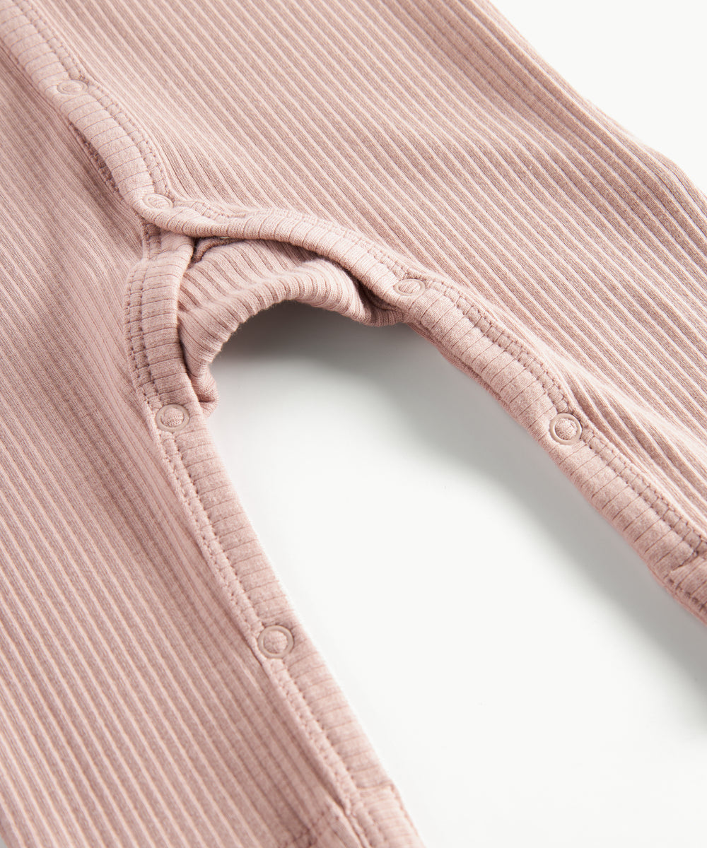 Ribbstrikket lyserød heldragt til baby i blødt materiale med lange ærmer og lange ben og tryknapper