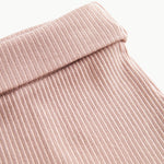 Nærbillede af ribstrikket elastisk talje på lyserøde leggings med fod til baby