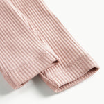 Detaljebillede af benåbning på lyserøde ribstrikkede bukser til børn