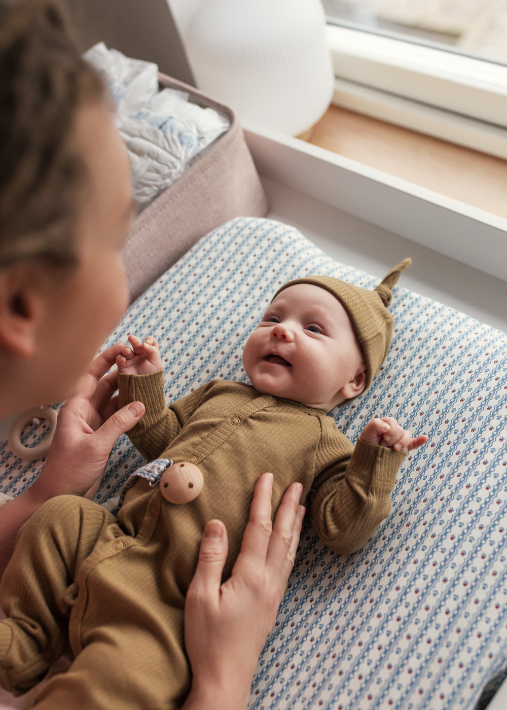 Baby i ribbstrikket brun heldragt til baby i blødt materiale med lange ærmer, lange ben, tryknapper og futter og brun babyhue