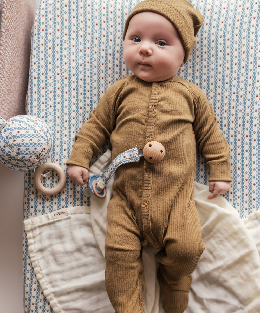 Baby iført brun ribstrikket hue og heldragt