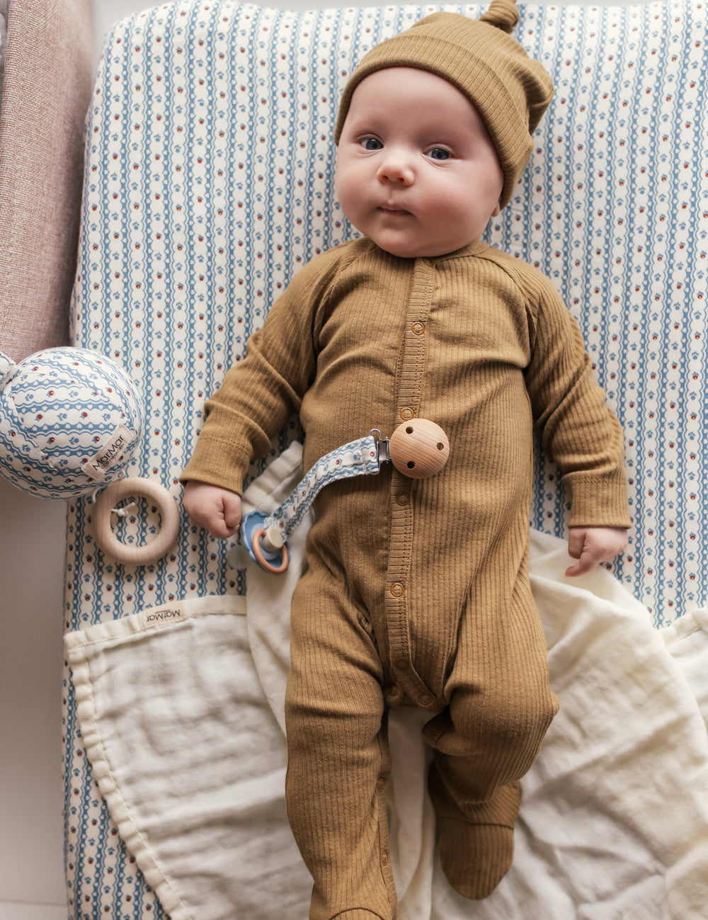 Baby med brun ribstrikket hat og holdt