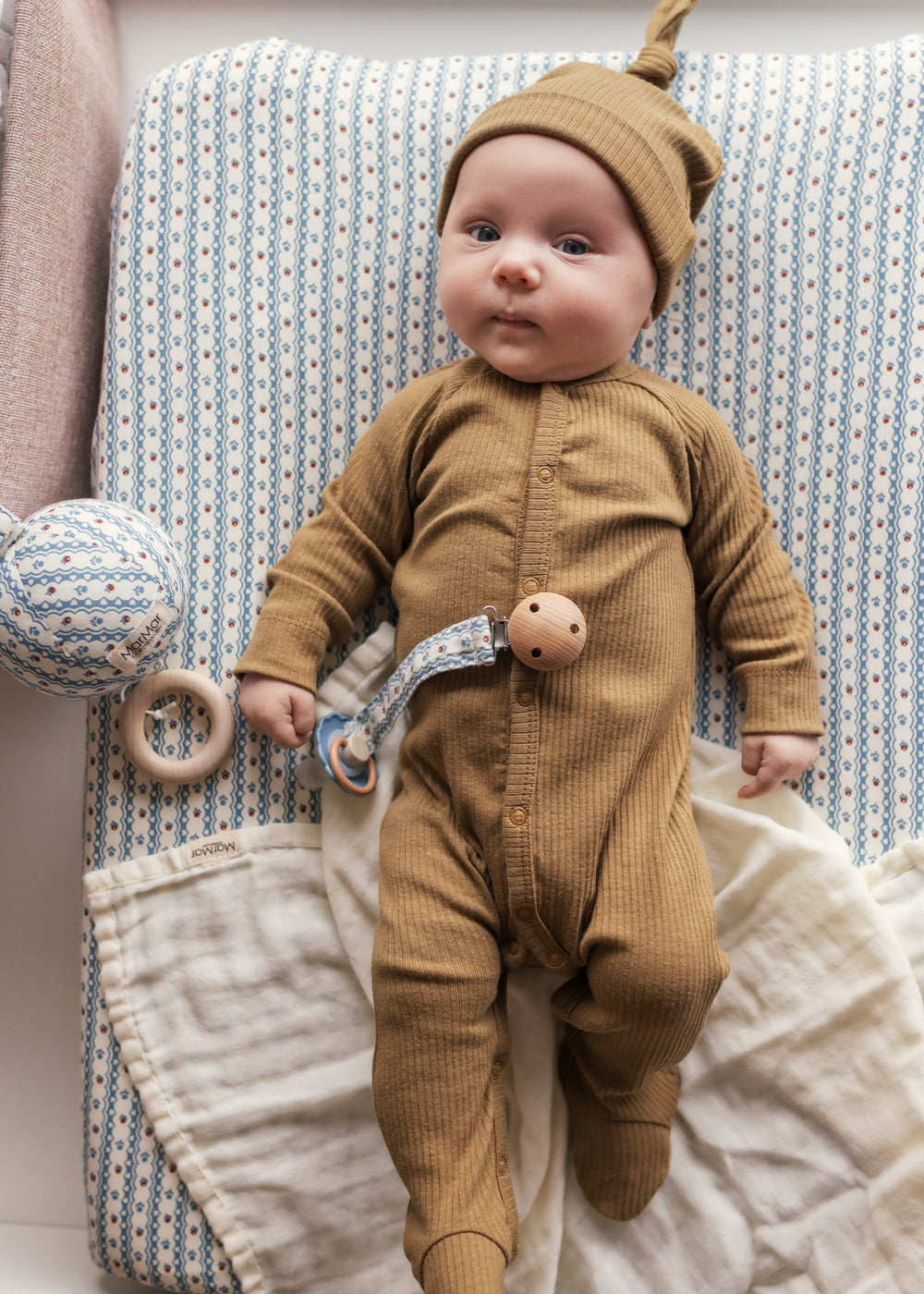 Baby i ribbstrikket brun heldragt til baby i blødt materiale med lange ærmer, lange ben, tryknapper og futter og brun babyhue