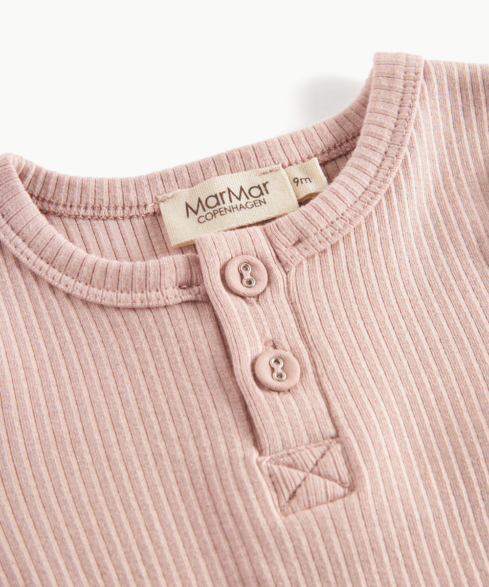Lyserød ribstrikket babybody med lange ærmer, stolpe knaplukning og trykknapper mellem benene