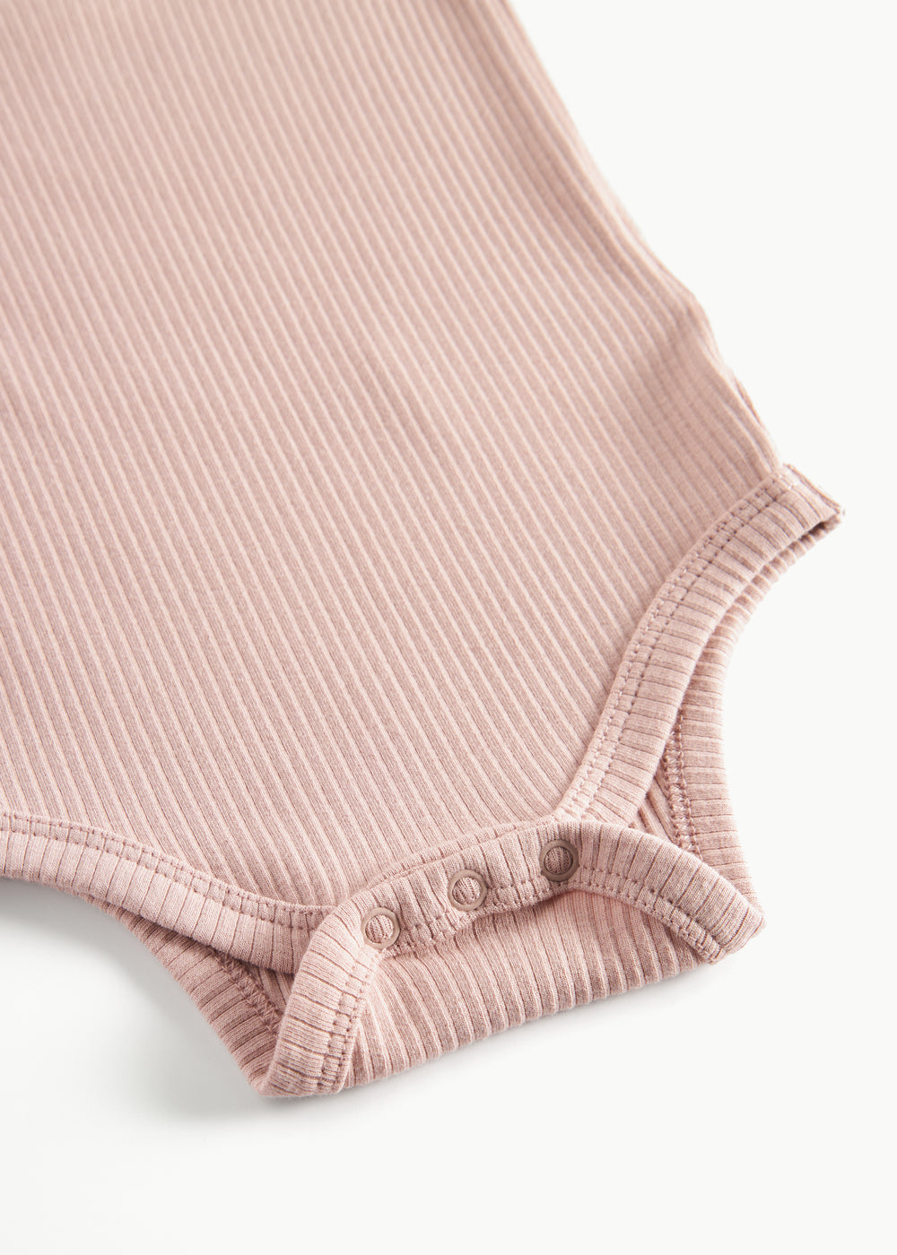 Lyserød ribstrikket babybody med lange ærmer, stolpe knaplukning og trykknapper mellem benene