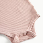 Lyserød ribstrikket babybody med lange ærmer, stolpe knaplukning og trykknapper mellem benene