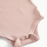 Lyserød ribstrikket babybody med lange ærmer, stolpe knaplukning og trykknapper mellem benene