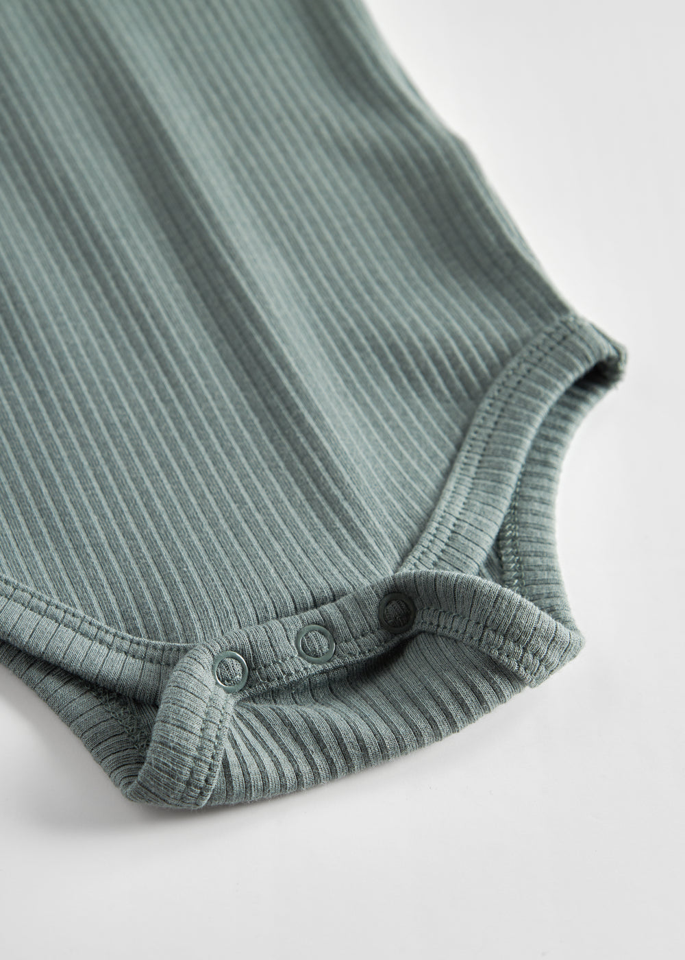 Grøn ribstrikket body med lange ærmer og knapper til baby