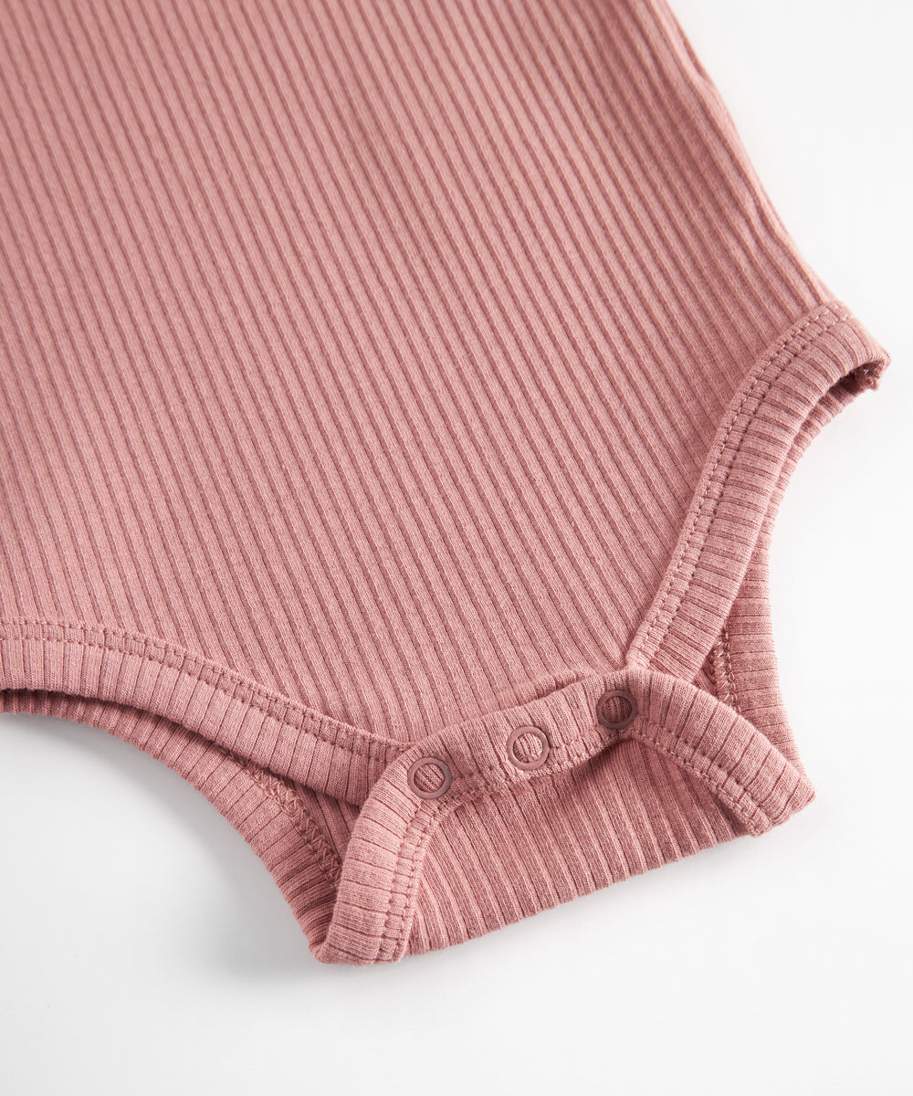 Lyserød ribstrikket babybody med lange ærmer og knapper