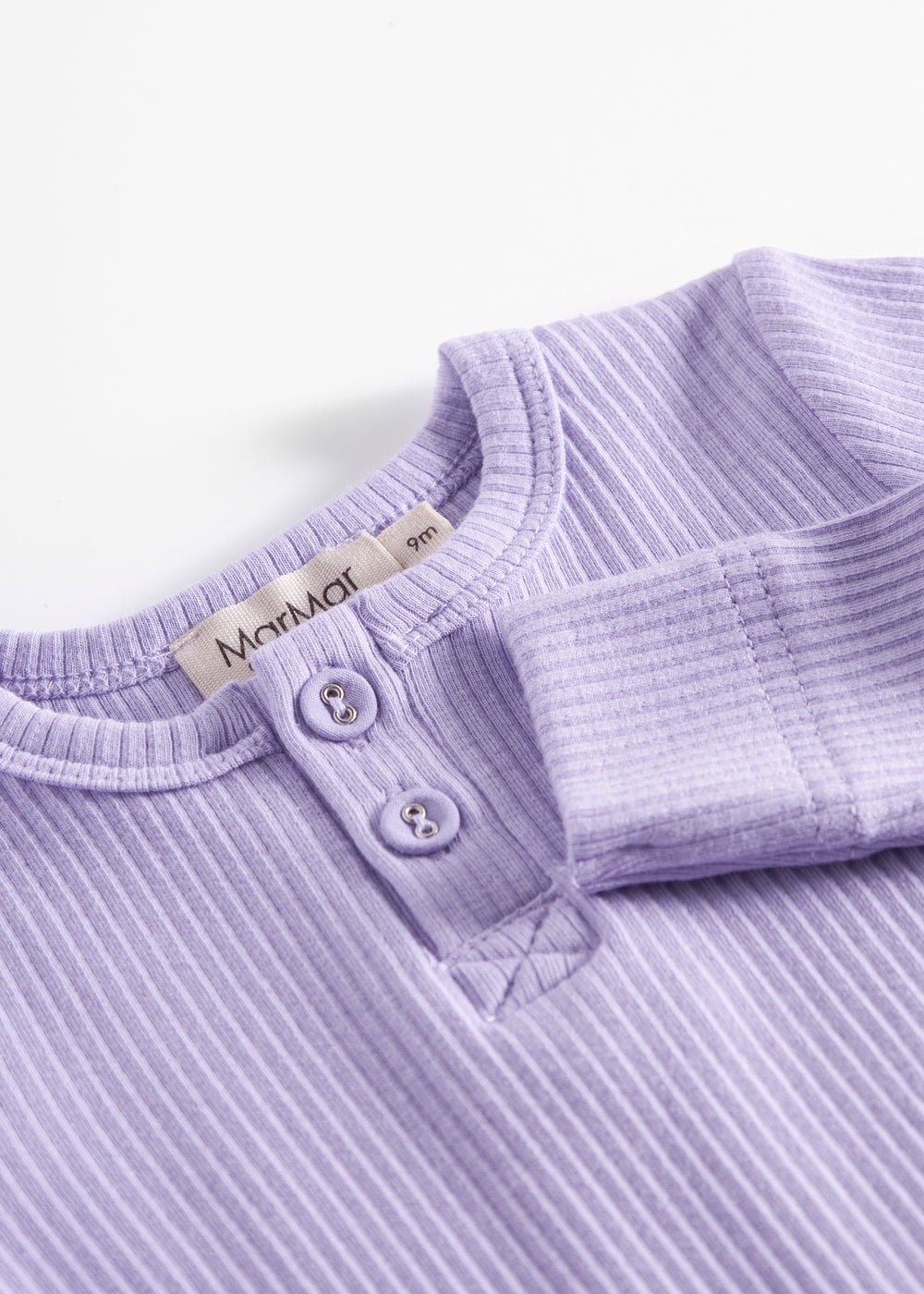 Lilla ribstrikket babybody med lange ærmer, stolpe knaplukning og trykknapper mellem benene