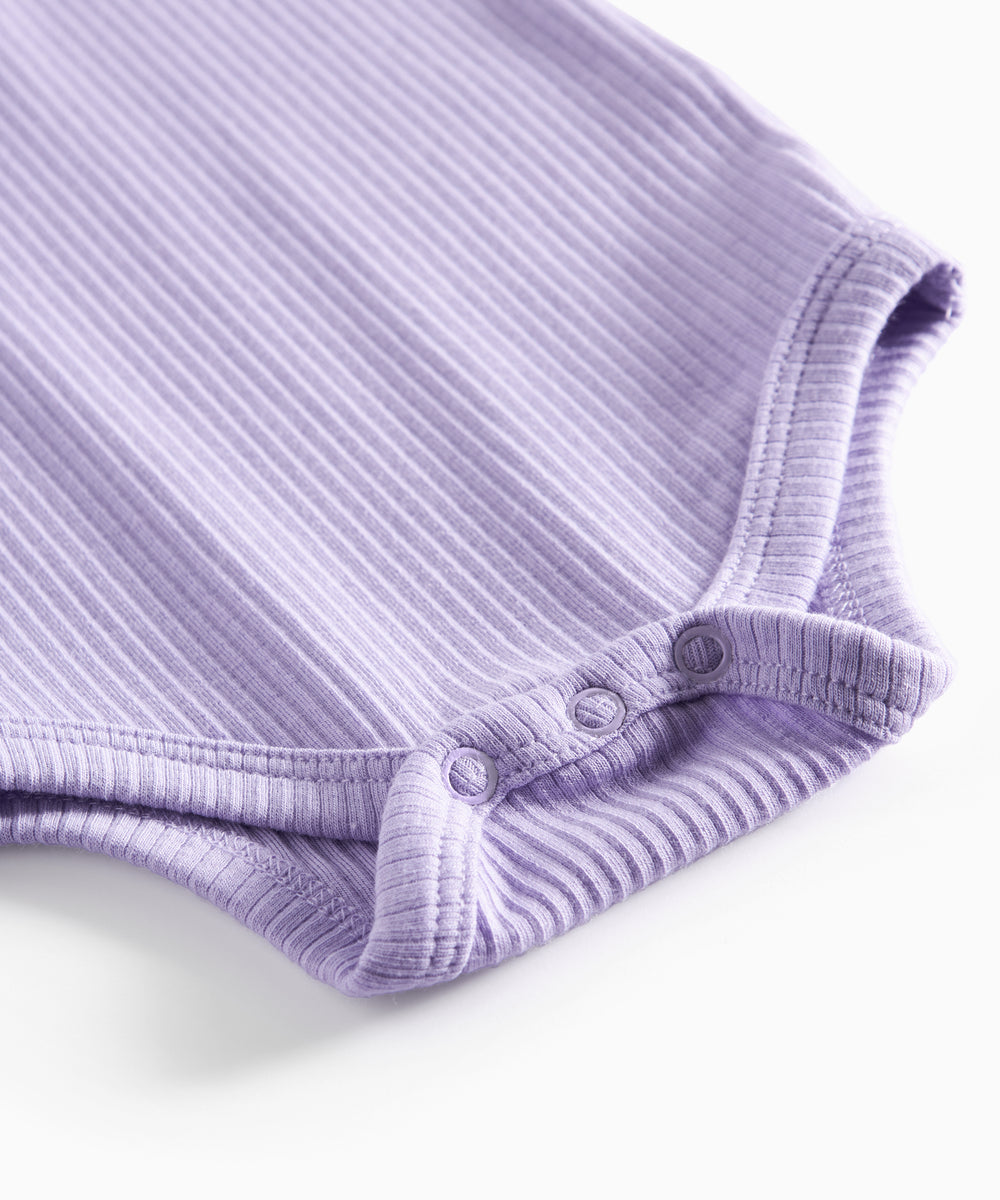 Lilla ribstrikket babybody med lange ærmer, stolpe knaplukning og trykknapper mellem benene