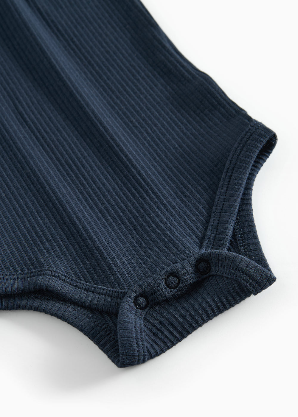 Blå ribstrikket babybody med lange ærmer, stolpe knaplukning og trykknapper mellem benene