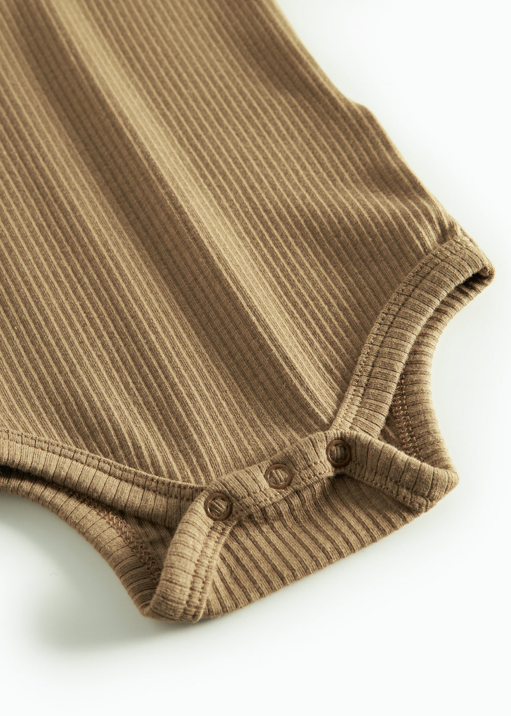 Brun ribstrikket babybody med lange ærmer, stolpe knaplukning og trykknapper mellem benene