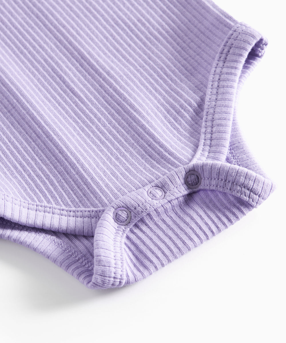 Lilla ribstrikket babybody med lange ærmer og knapper mellem benene