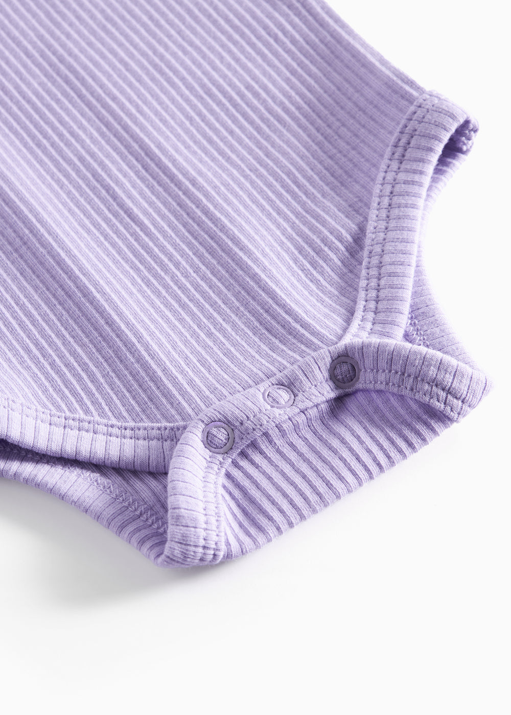 Lilla ribstrikket babybody med lange ærmer og knapper mellem benene