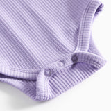 Lilla ribstrikket babybody med lange ærmer og knapper mellem benene