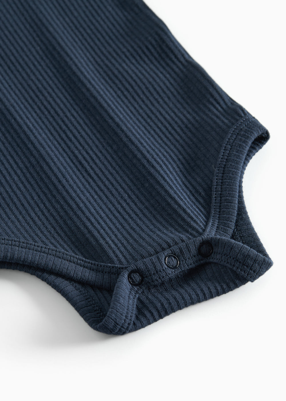 Blå ribstrikket babybody med lange ærmer og knapper mellem benene