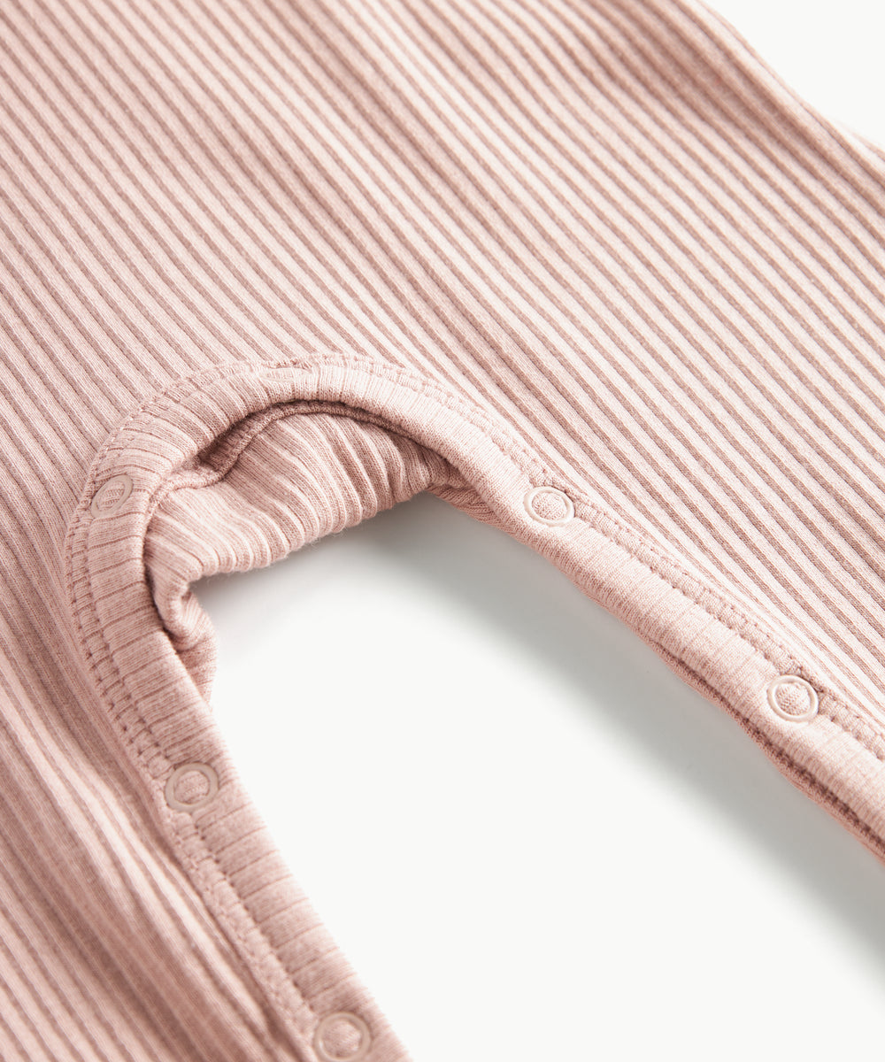 Ribbstrikket lyserød heldragt til baby i blødt materiale med lange ærmer, lange ben og knapper