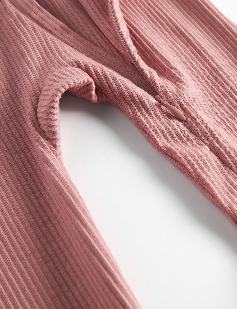 Lyserød ribstrikket holdt med lange lange ærmer og tiltil baby