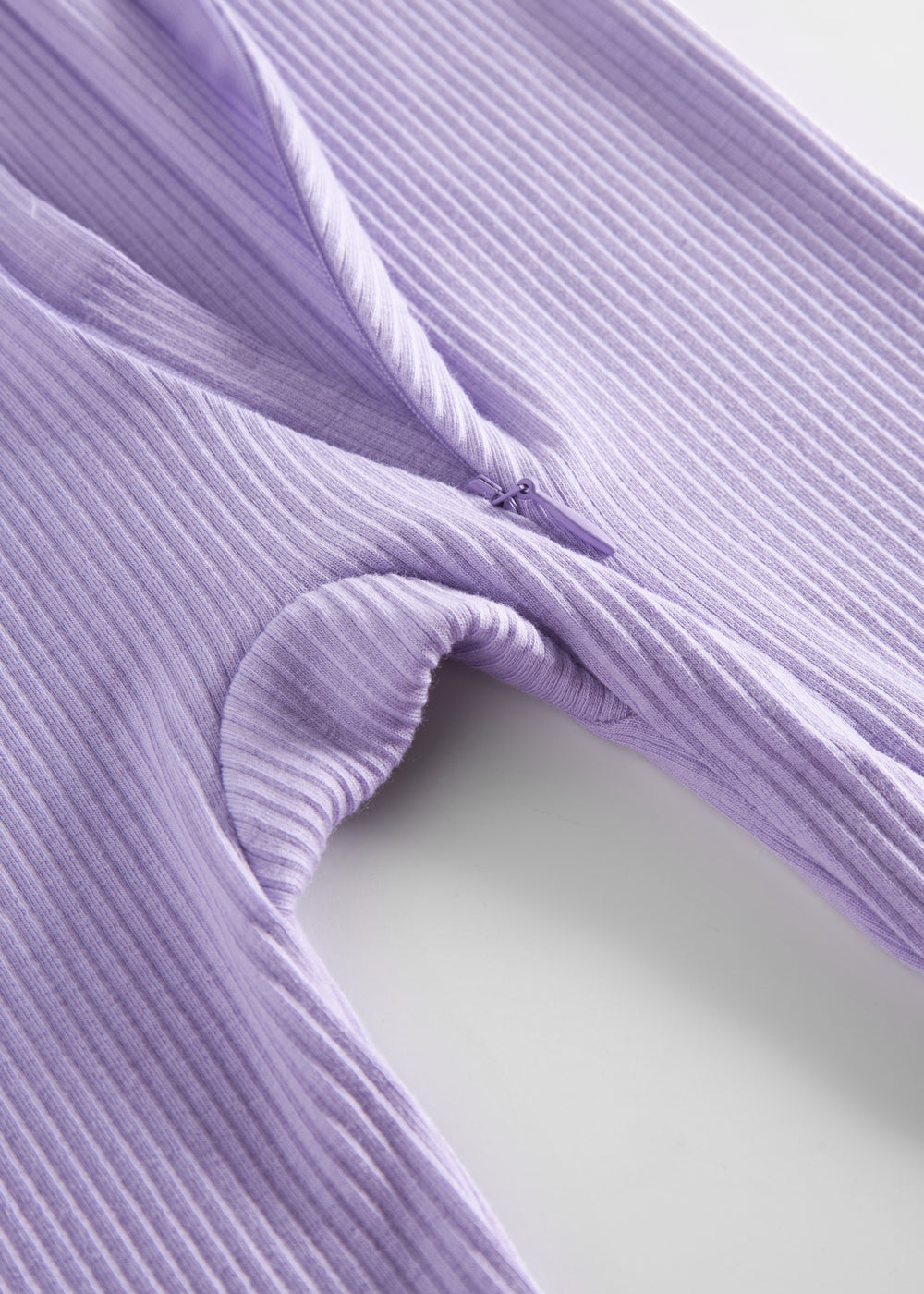 Ribbstrikket lys lilla heldragt til baby i blødt materiale med lange ærmer og lange ben og lynlås