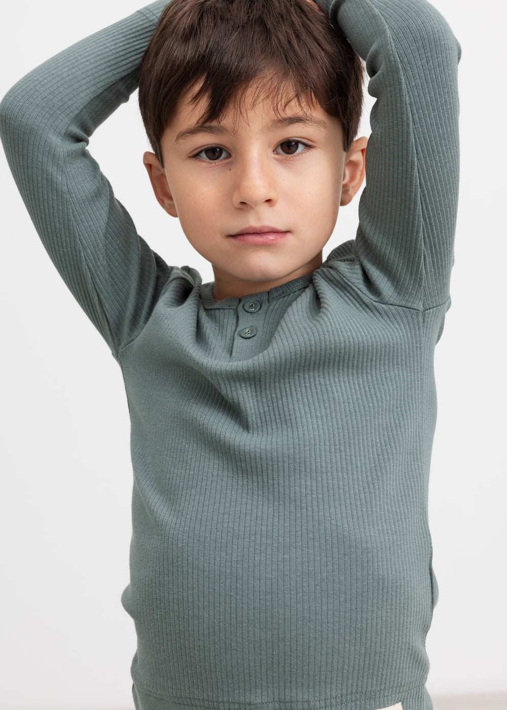 Dreng i grøn ribstrikket t-shirt løfter armene