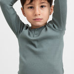 Dreng i grøn ribstrikket t-shirt løfter armene