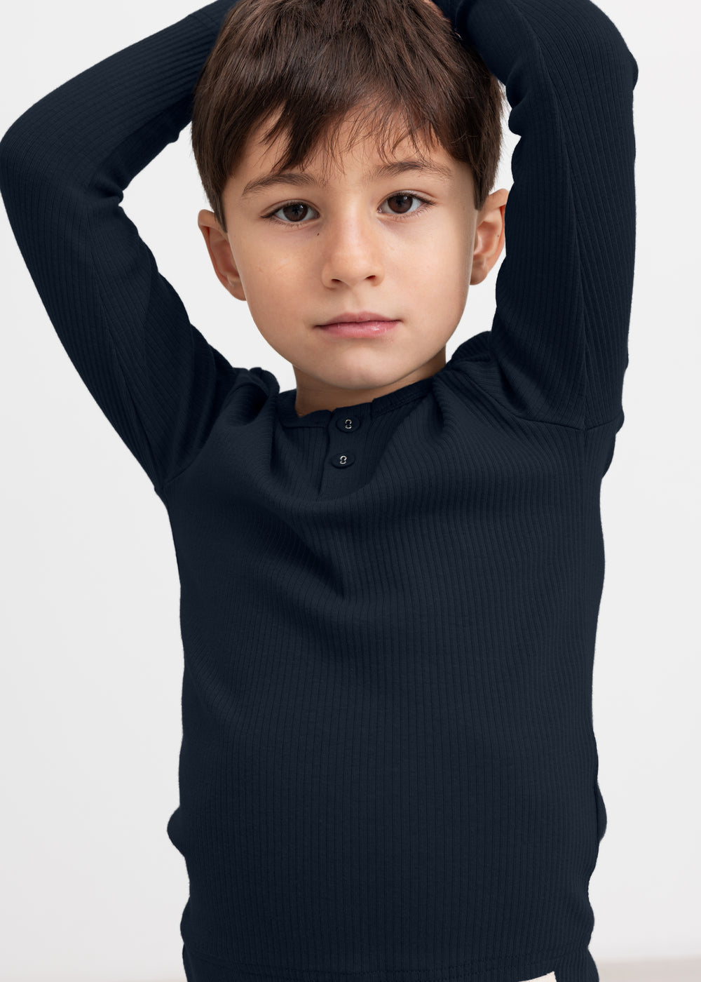 Dreng iført blå ribstrikket langærmet t-shirt med knapper