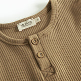 Detalje af brun ribstrikket langærmet t-shirt med knapper