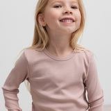 Glad pige iført langærmet rosa ribstrikket t-shirt til børn