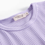 Detalje af ribstrikket lilla børnetøj med mærke