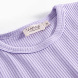 Detalje af ribstrikket lilla børnetøj med mærke