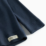 Nærbillede af ribstrikket stof og mærkat på navyblå børne t-shirt