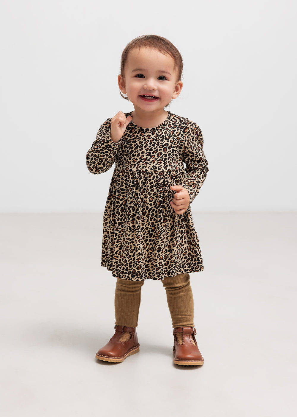 Barn i brun ribstrikket kjole med leopardmønster og brune leggings