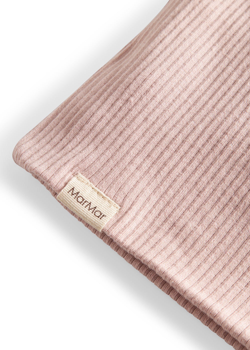 Detalje af ribstrikket lys rosa stof og mærke på børnehue