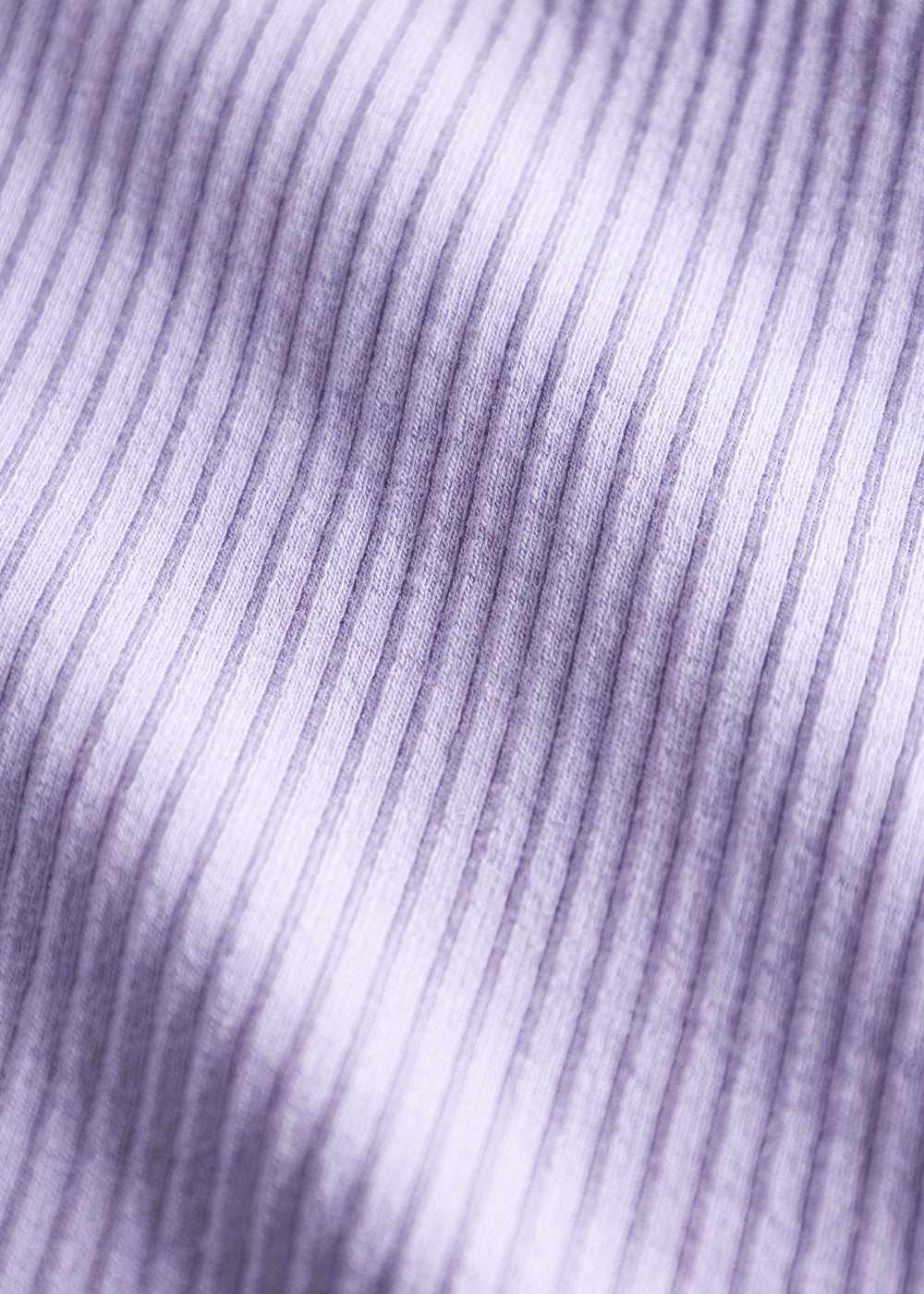 Detalje af lyse lilla ribstrikket stof på børnehue