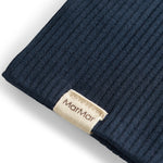 Detalje af ribstrikket navy blå stof og mærke på børnehue