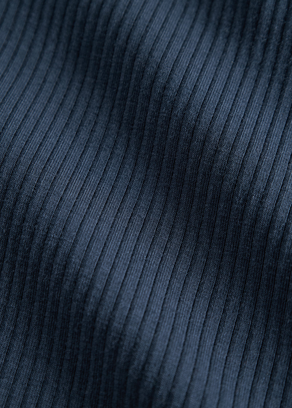 Detalje af navy blå ribstrikket stof på børnehue