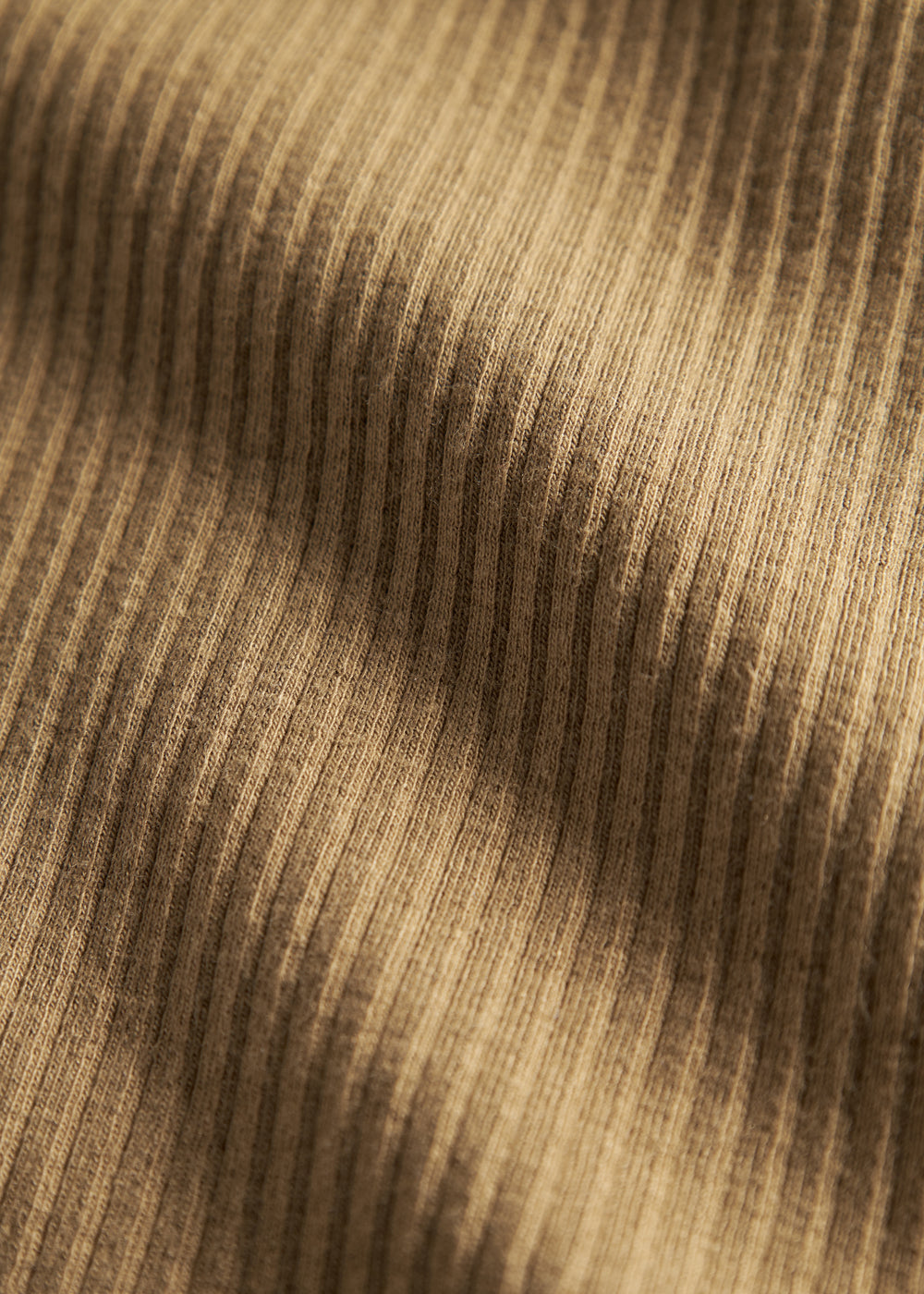 Detalje af ribstrikket brunt stof på børnehue