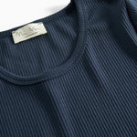 Detalje af ribstrikket stof ved halsudskæringen på mørkeblå t-shirt til dame