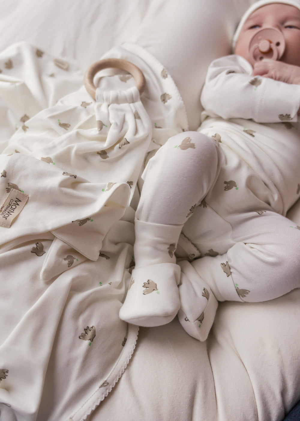 Baby med bidering i blødt stof med mønster