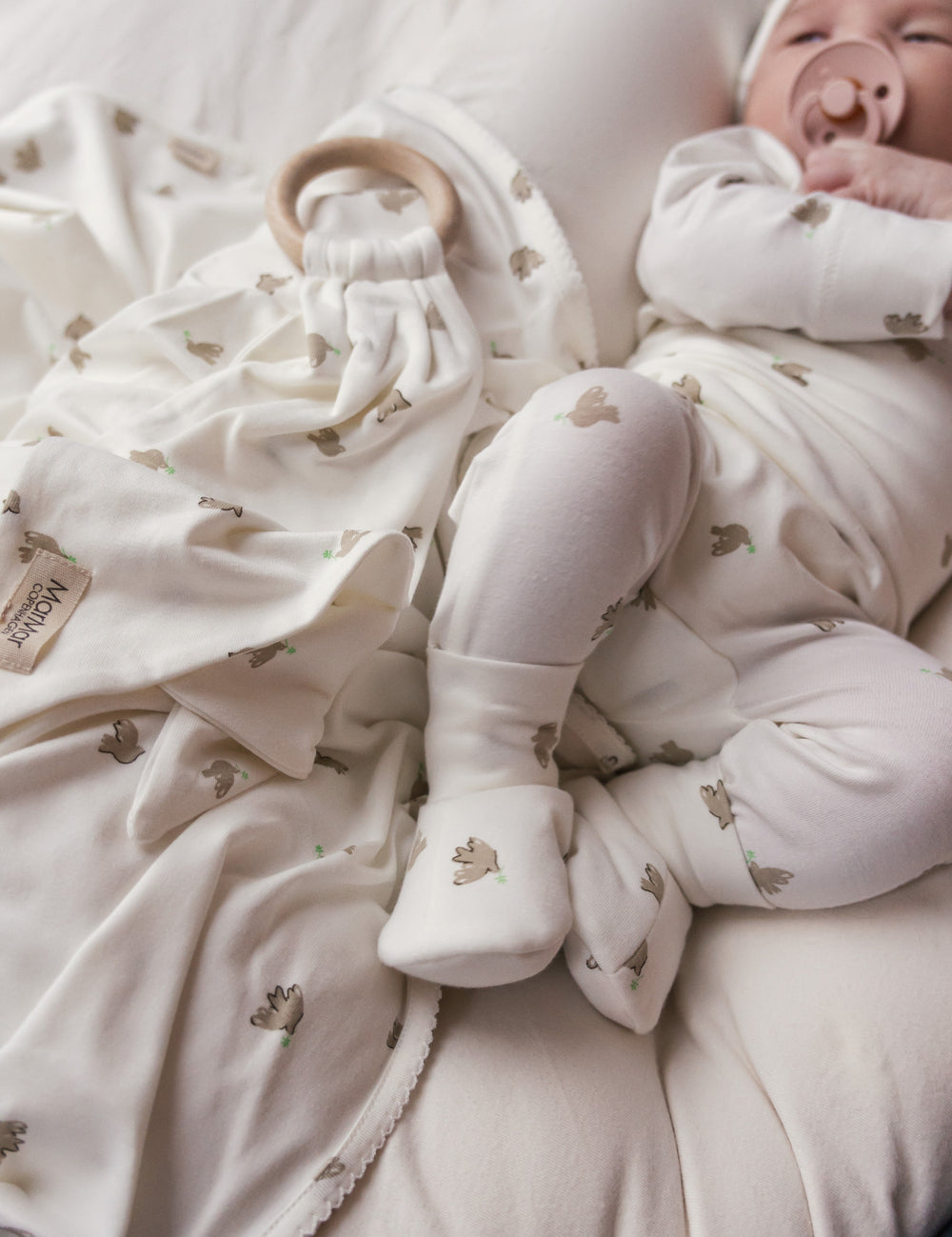 Baby i holdt med fuglmønster og futter