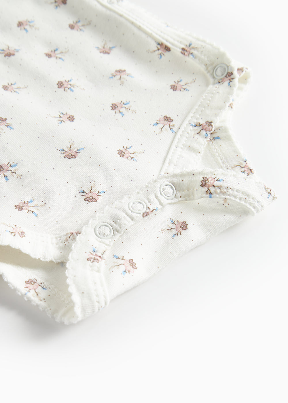 Langærmet bodystocking til nyfødte med slå-om-lukning og blomstermønster