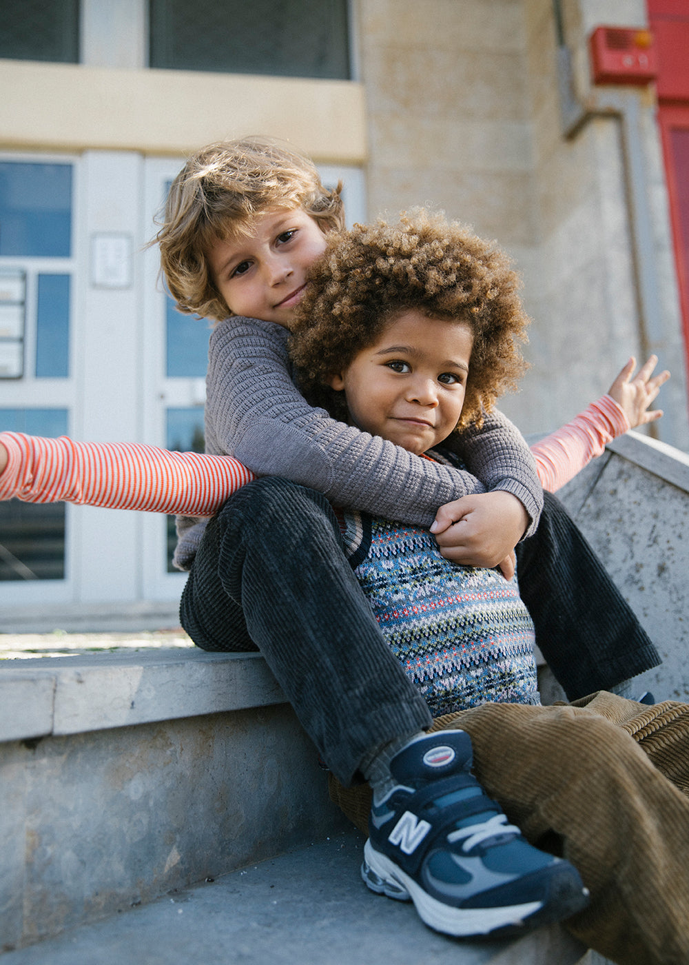 To børn iført stribede bluser i forskellige farver