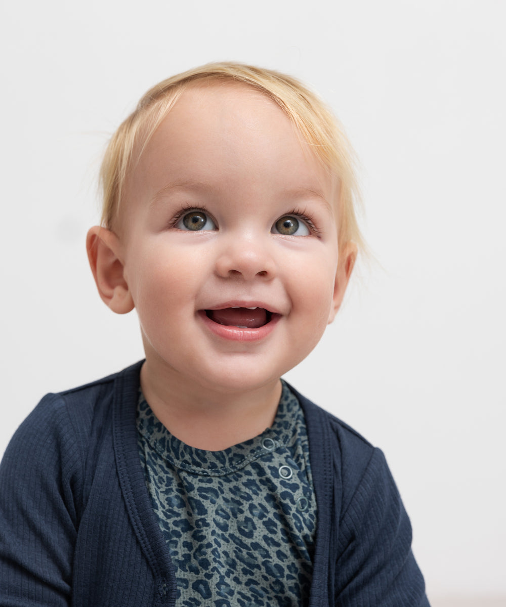 Børn iført marineblå ribstrikket cardigan