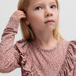 Pige iført lyserød leopardmønstret bluse med flæsedetalje